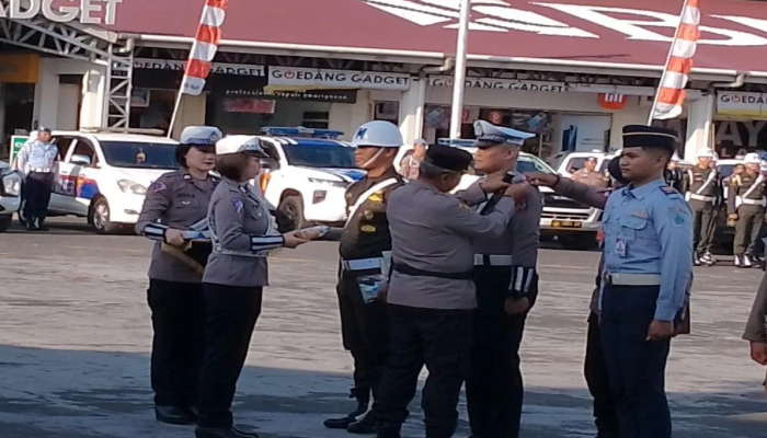 Irjen Pol Setyo Budiyanto, Kapolda Sulut, memasang pita operasi kepada seorang perwakilan dari personel saat menghadiri apel gelar pasukan Operasi Zebra Samrat 2023.