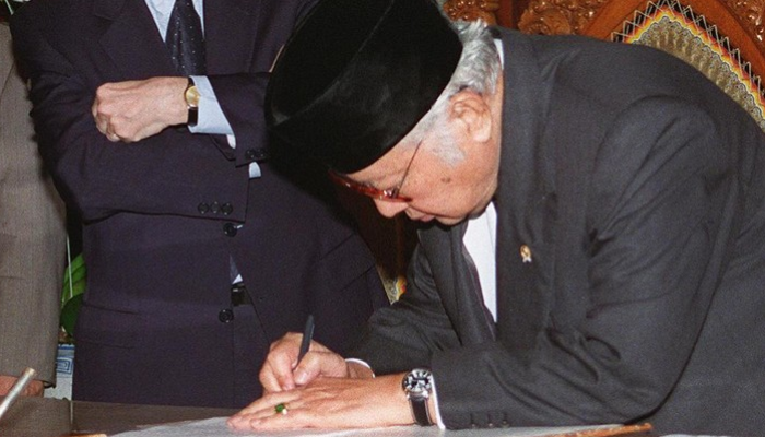 Foto arsip dari 15 Januari 1998 menampilkan Presiden Indonesia saat itu, Soeharto, menandatangani perjanjian baru di hadapan Direktur Jenderal Dana Moneter Internasional (IMF), Michel Camdessus, di kediamannya di Jakarta.