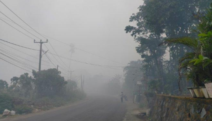 Jalan di Kelurahan Buha, Manado, Sulawesi Utara yang menghubungkan Kecamatan Mapanget dan Tuminting diselimuti asap dari kebakaran TPA Sumompo.