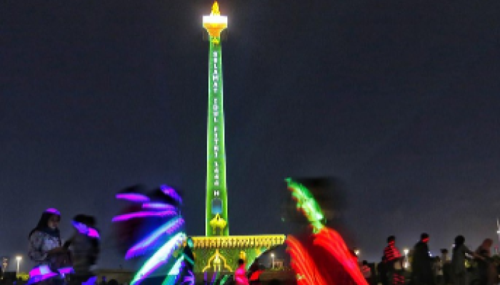 Pada 23 April 2023, pengunjung menonton video mapping di Monas Jakarta, Indonesia.